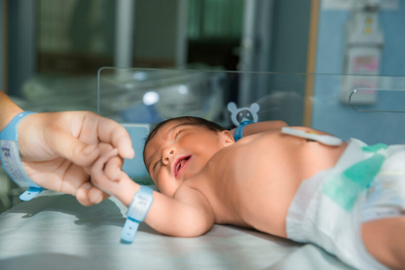 father-holds-hand-newly-born-babe-diapers-830x553.jpg