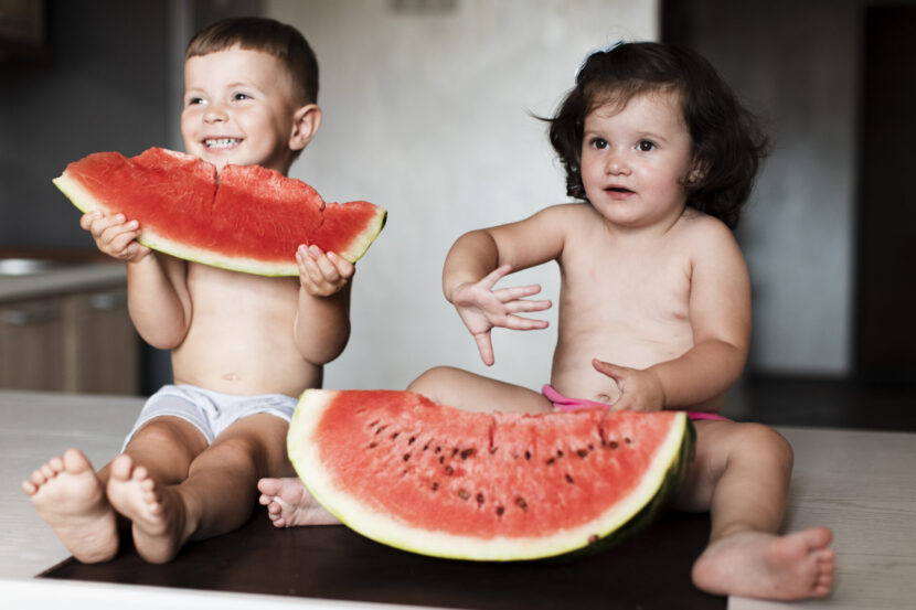 young-siblings-eating-watermelon-slices-830x553.jpg